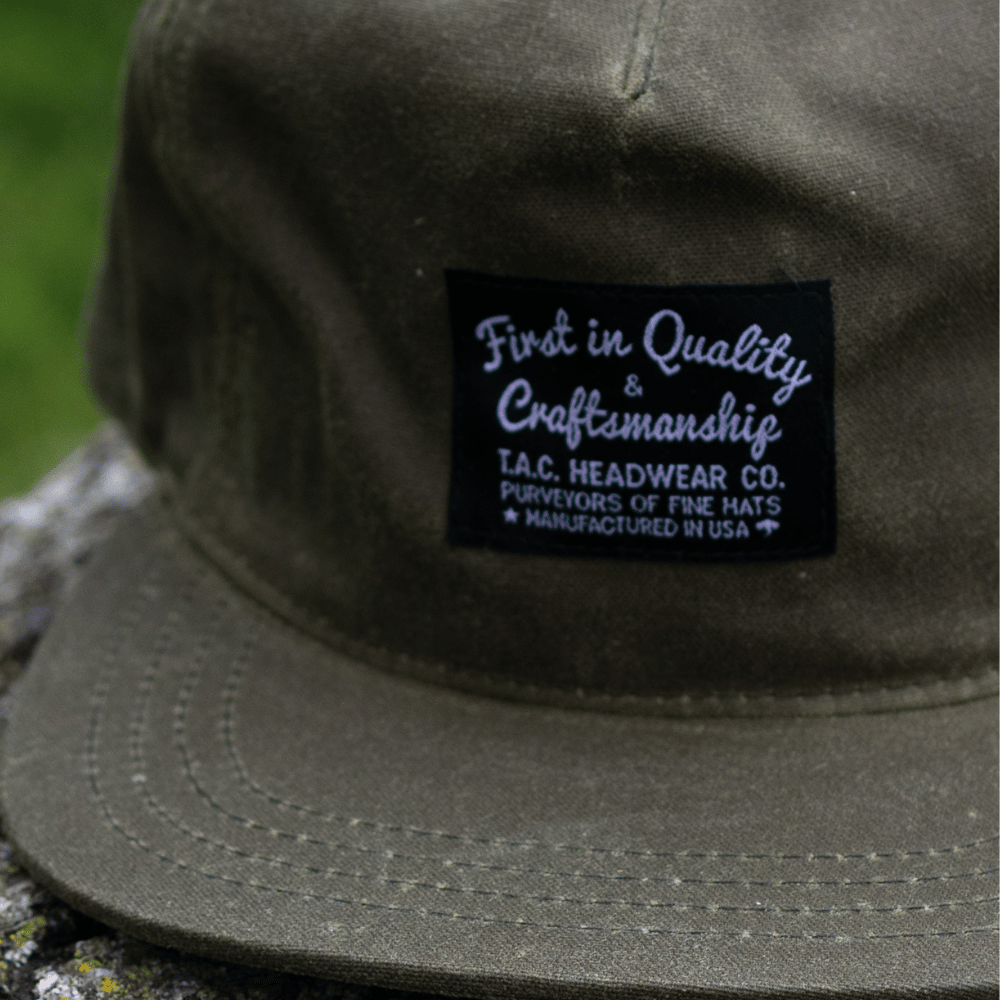 Olive Wax Snapback Hat by The Ampal Creative. Front label view.