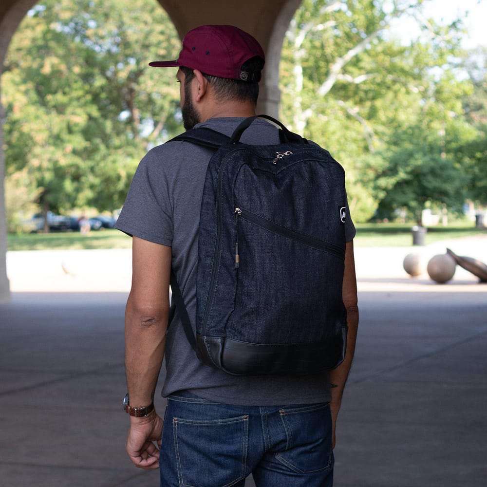 Fremont Recycled Denim Backpack by Alchemy Goods. Left-side worn view.