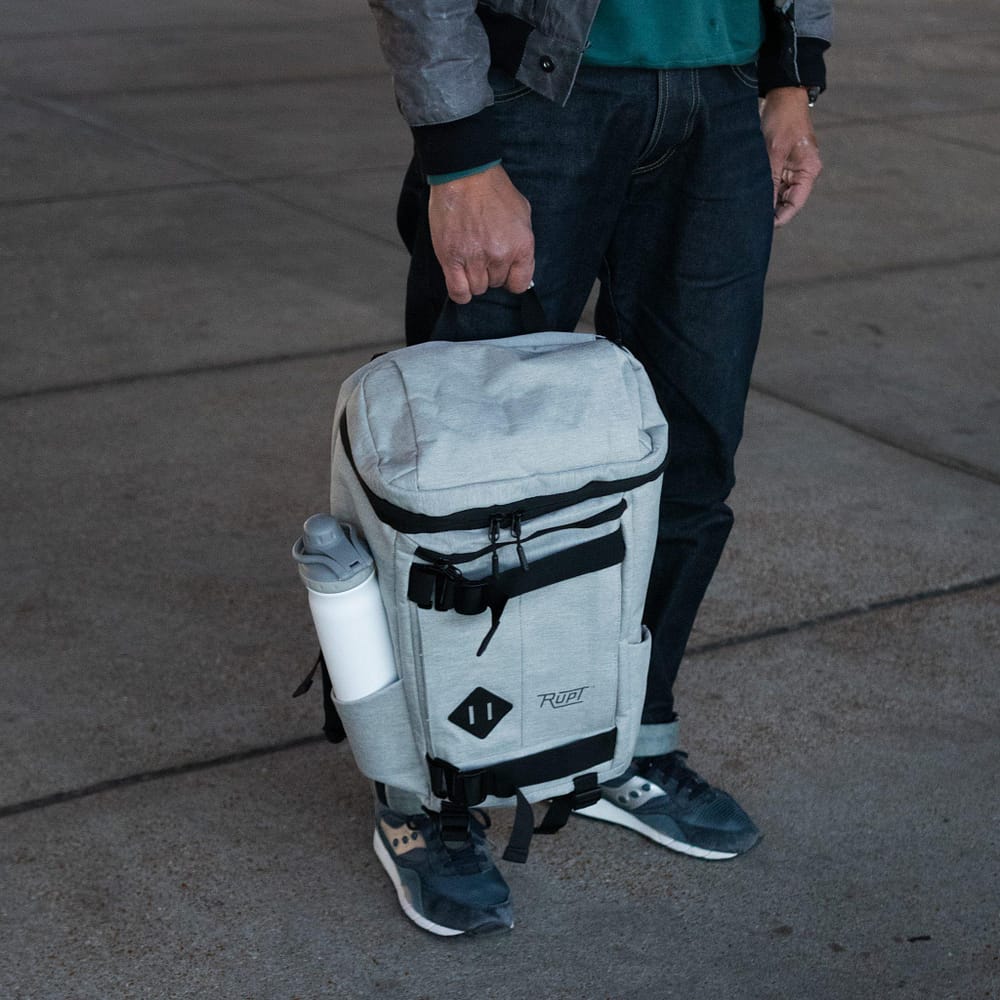 Paso 20L Backpack by Rupt in gray. Holding top handle view.